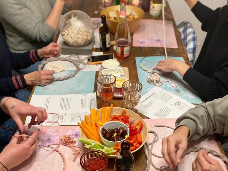 Workshop Gemeinsames Essen und Basteln an einem Tisch mit verschiedenen Snacks und Getränken.
